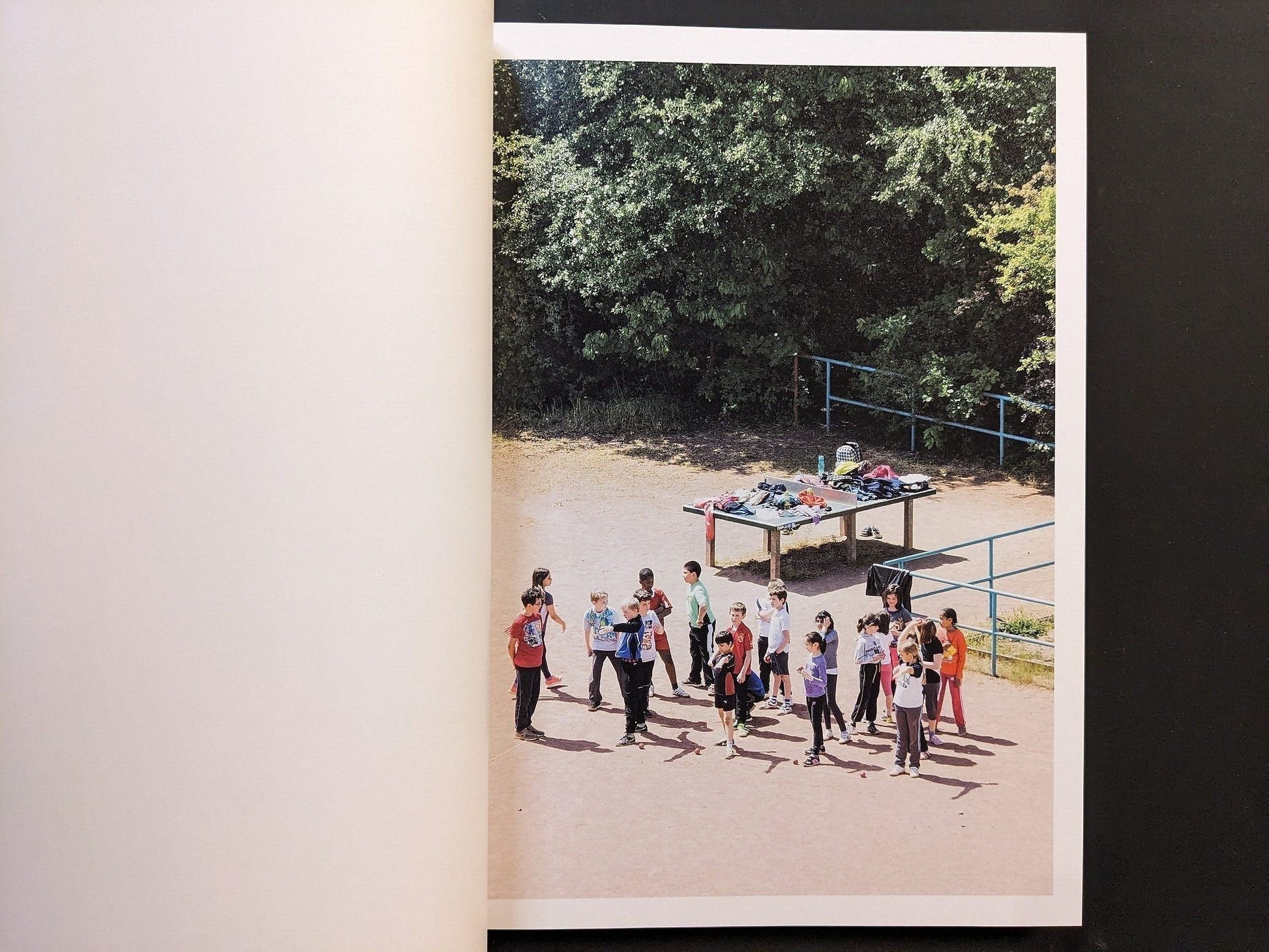 Photograph of a group of children gathered near the table tennis area.