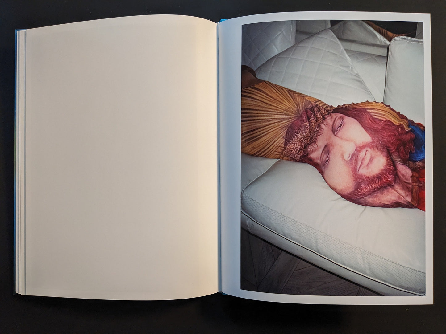 Open spread from ¥€$U$ (JESUS) showing a body pillow printed with Jesus on a white sofa.