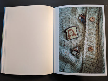 Open spread from ¥€$U$ (JESUS) showing a knitted cardigan decorated with Jesus-themed novelty badges.