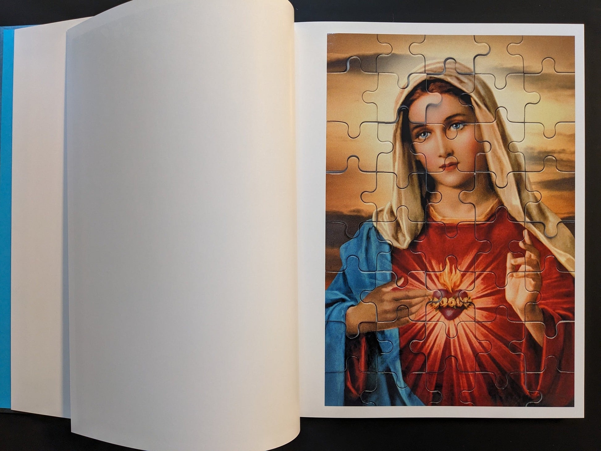 Open spread from ¥€$U$ (JESUS) showing a jigsaw puzzle image of the Virgin Mary with the Sacred Heart motif.
