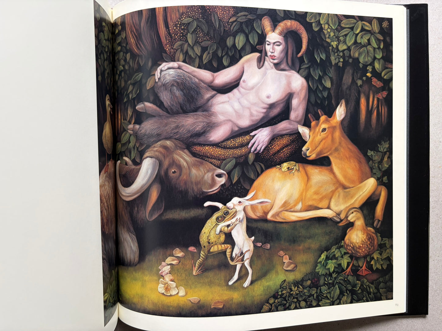 Open spread from VANITAS showing a reclining nude figure with animals in a wooded scene.