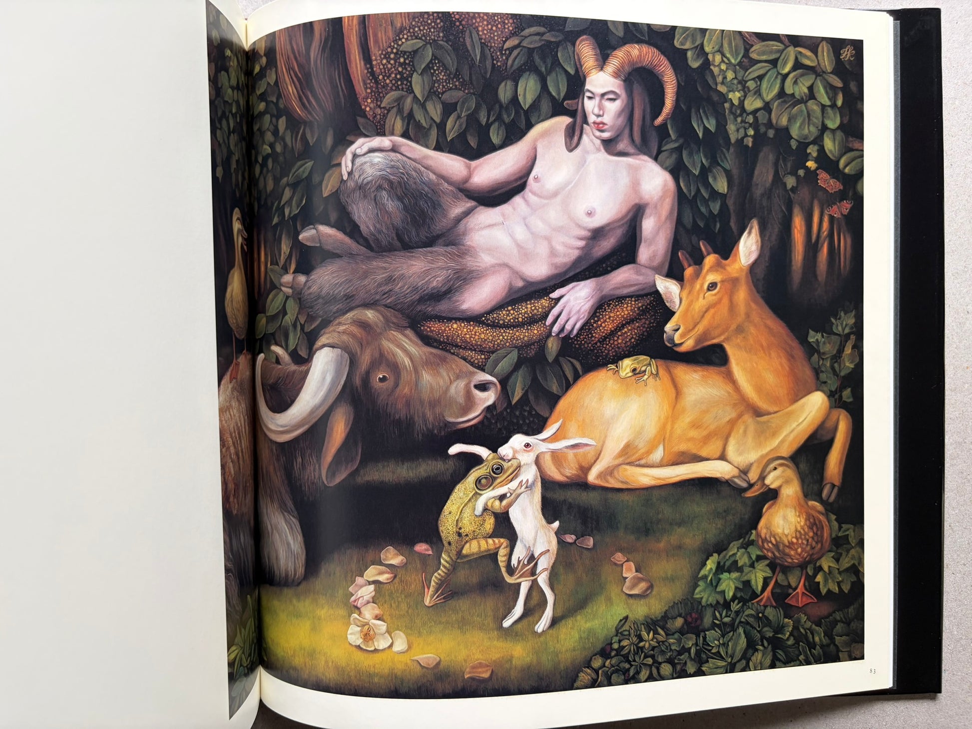 Open spread from VANITAS showing a reclining nude figure with animals in a wooded scene.