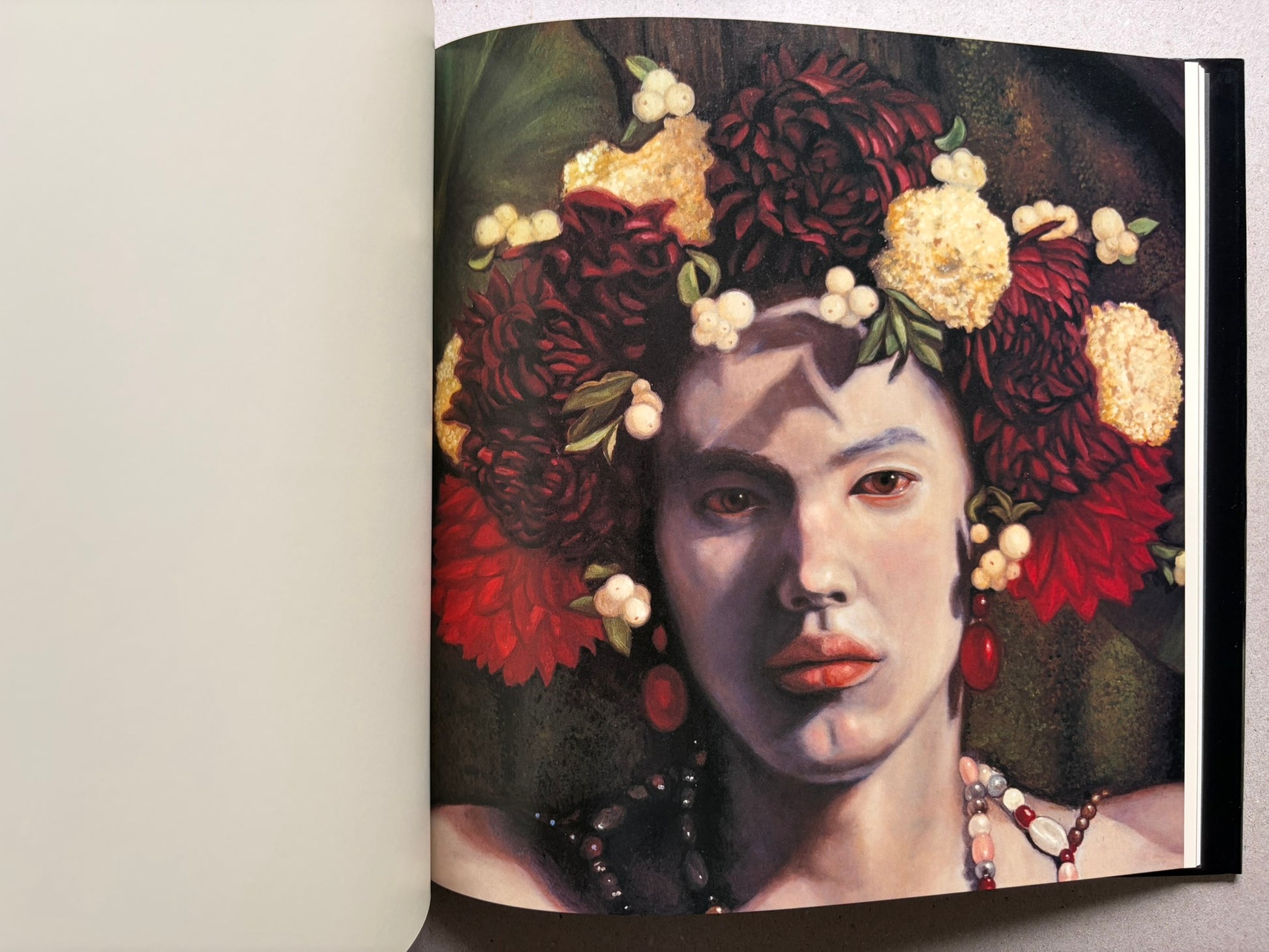 Open spread from VANITAS showing a portrait of a person with red flowers and beads.