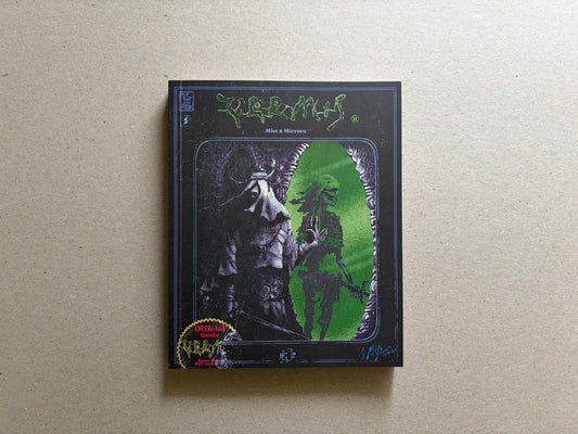 Vermis II – Mist & Mirrors by Plastiboo, front cover on a neutral tabletop, showing the black softcover with green title lettering and a central green portal illustration.