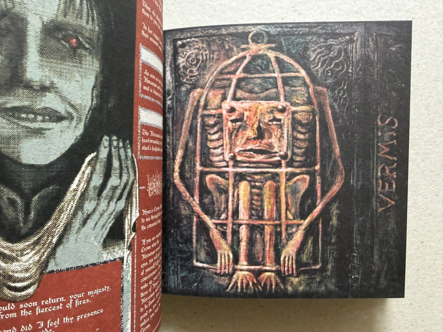 Open Vermis III spread with a close-up face on the left page and a caged figure illustration on the right page.