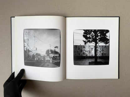 Open spread of Walk while ye have the light by Yoshiichi Hara, showing two black-and-white photographs on facing pages.
