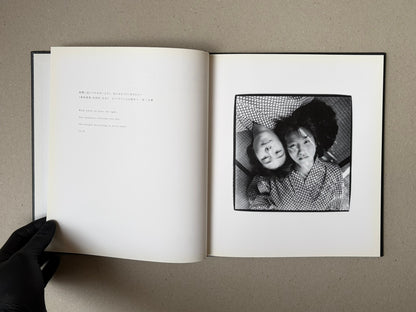 Open spread of Walk while ye have the light by Yoshiichi Hara, with a title page on the left and a black-and-white photograph of two faces on the right.