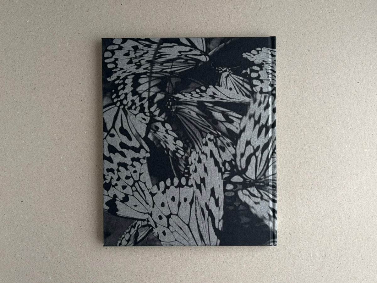 Wandering Dog by Mai Nakama, back cover of a black-and-white photobook with overlapping butterfly wings on the cover