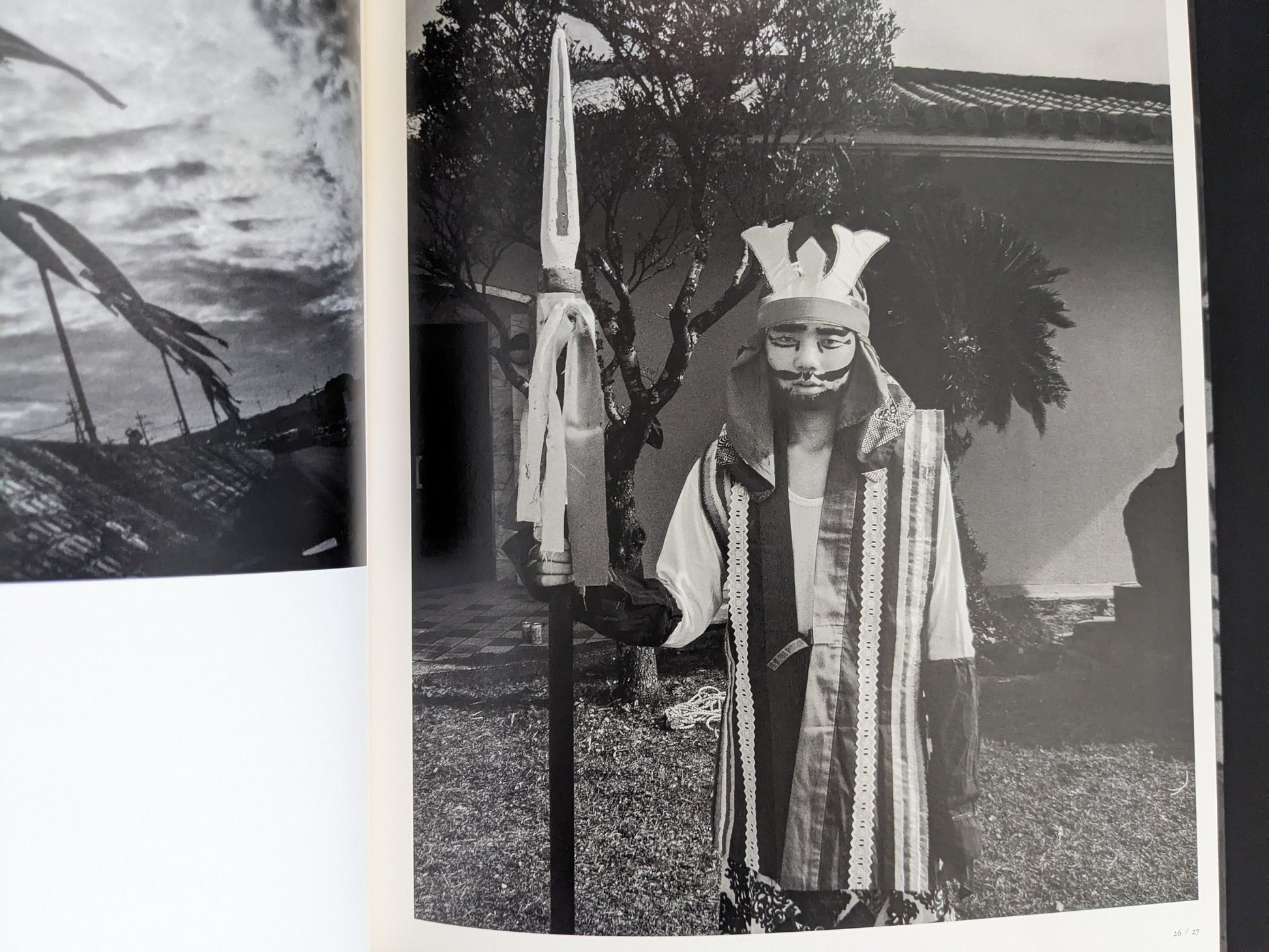 Black and white photo of masked performer holding spear in Wandering Dog