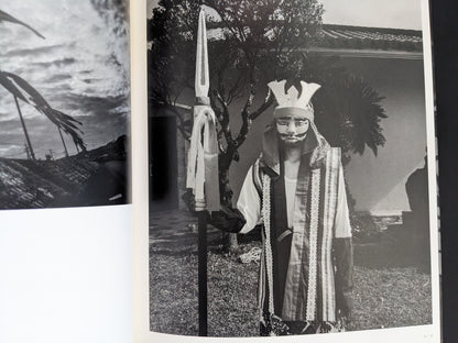 Black and white photo of masked performer holding spear in Wandering Dog