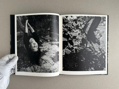 Wandering Dog by Mai Nakama, open photobook spread with a black-and-white portrait on the left and dense foliage on the right.
