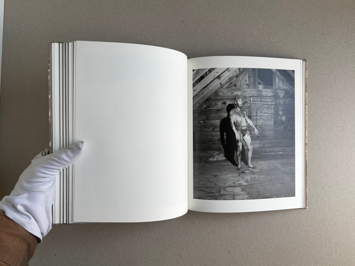 Open copy of What the Rain Might Bring by Dylan Hausthor, showing a blank left page and a black-and-white photograph on the right page.