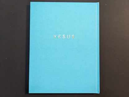Turquoise cloth hardcover of the photobook “¥€$U$ (JESUS)” by Pawel Jaszczuk with the foil-stamped title on the front.