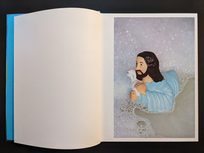 Inside page from “¥€$U$ (JESUS)” of a plastic Jesus figure holding a lamb, floating in a bathtub filled with foam.