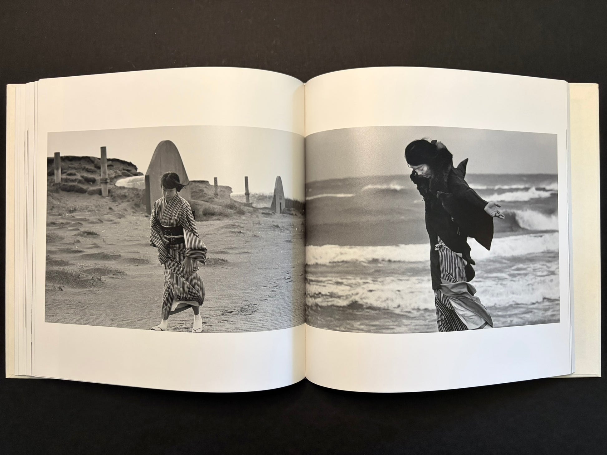 Open spread with two full-bleed black-and-white photographs of Yoko in striped clothing by the sea.