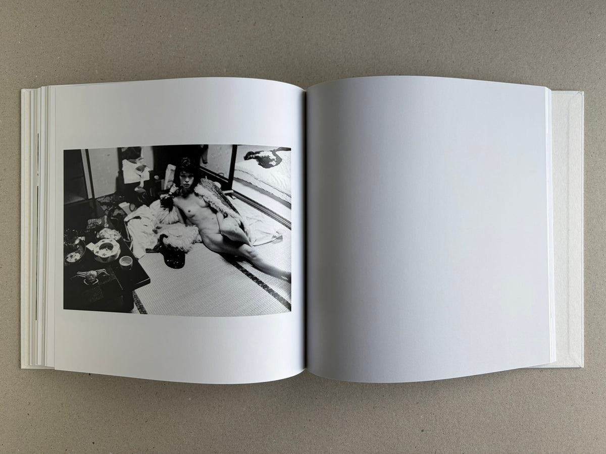 Yoko – Masahisa Fukase, spread with a nude figure reclining on tatami on the left and a blank page on the right.