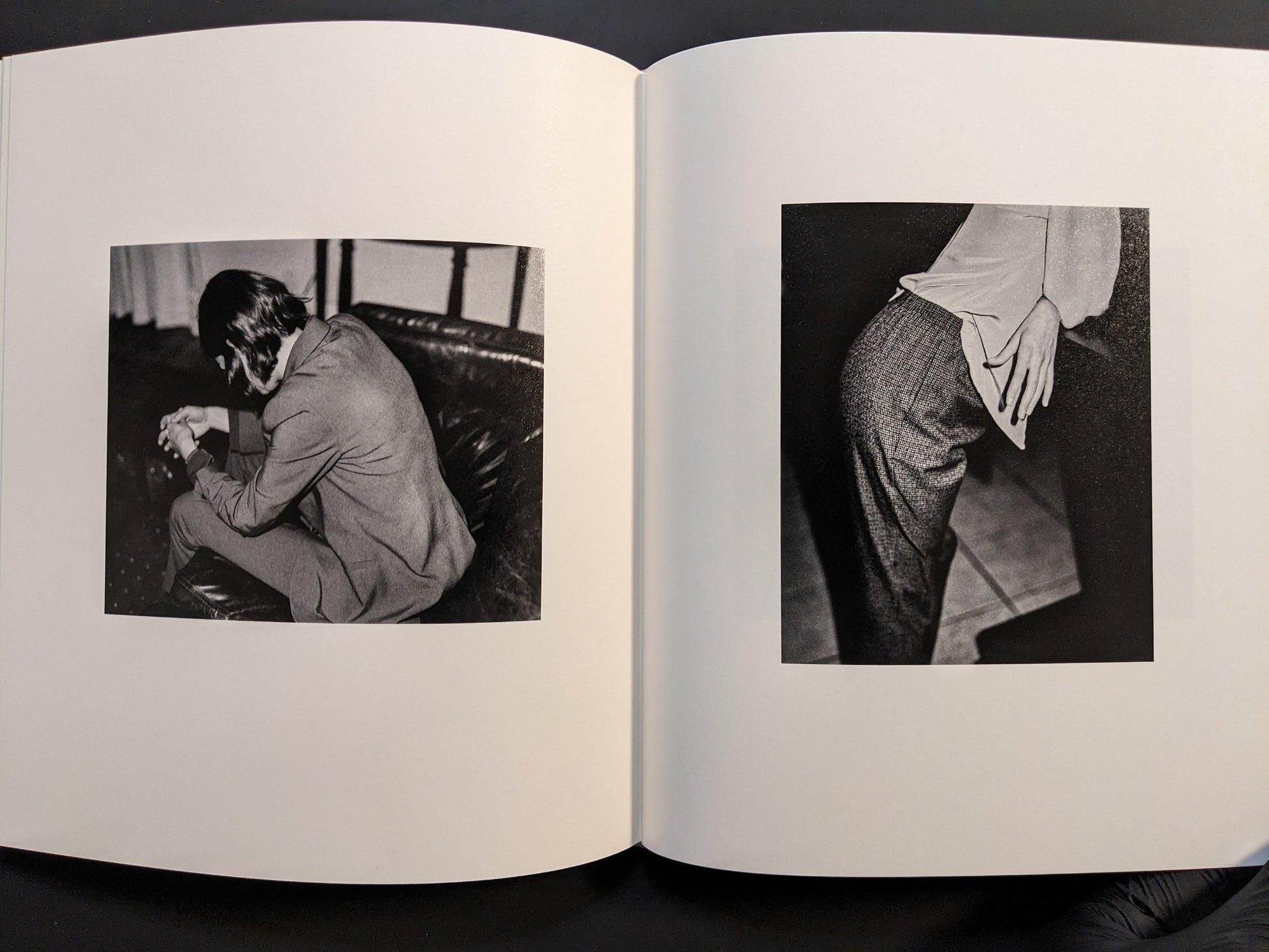Interior spread featuring two black-and-white photographs — one of a seated man and one showing a close-up of a hand on fabric.