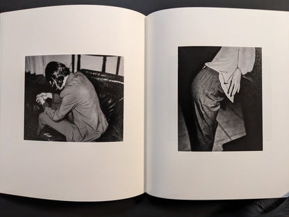 Interior spread featuring two black-and-white photographs — one of a seated man and one showing a close-up of a hand on fabric.